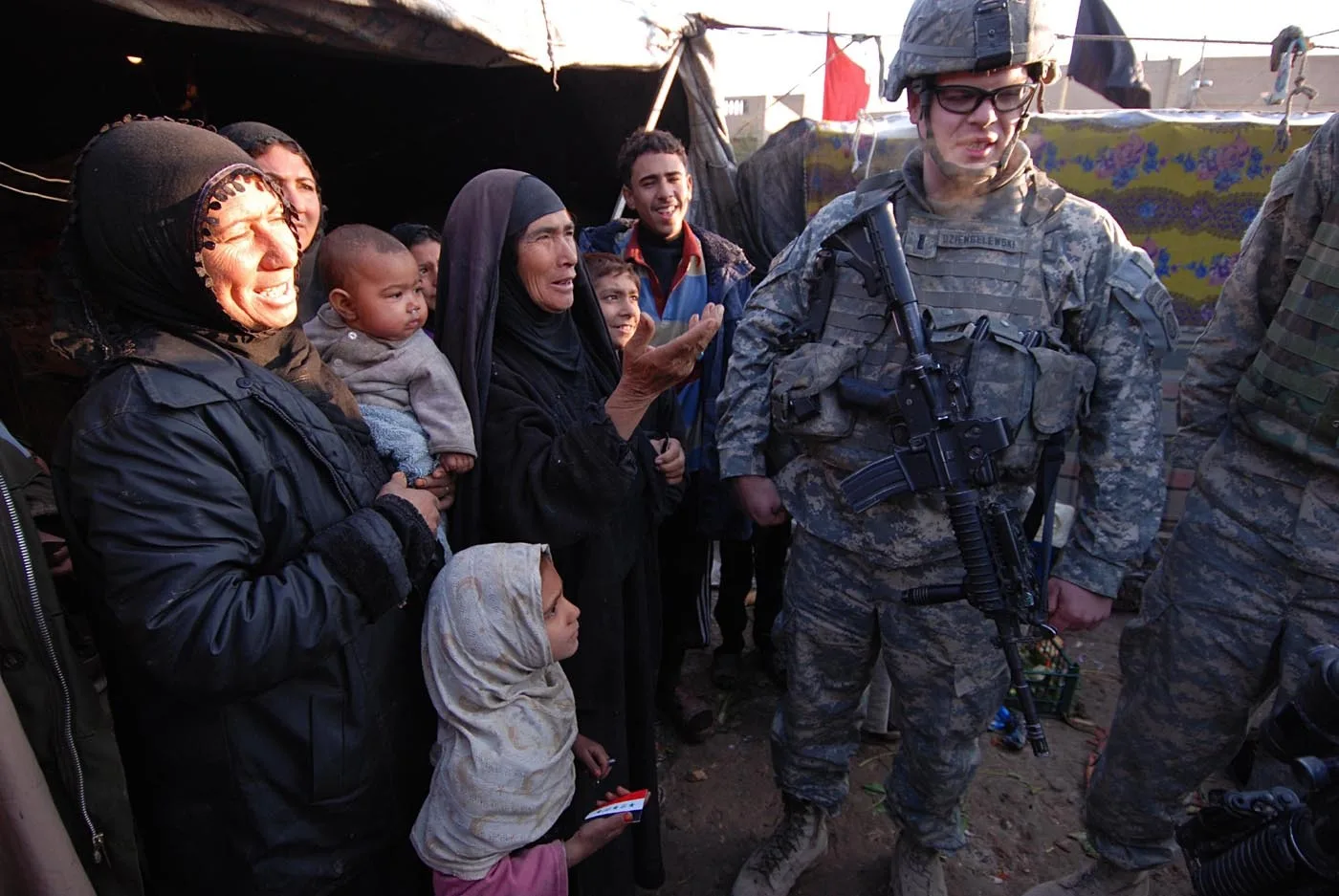Springfield, Mass. native 1st Lt. Austin Dziengelewski, a platoon leader with Company B, 2nd Battalion, 325th Airborne Infantry Regiment, 2nd Brigade Combat Team, 82nd Airborne Division, gets information from a family of displaced squatters after discovering their refugee camp, Jan. 14. After sectarian violence forced the family to flee their home in another part of Baghdad, they now live in a squalid, makeshift shelter with other refugees in the Sha'ab neighborhood, where 2-325 operates. Later that night, the paratroopers dropped off some supplies to help the family get through the winter.