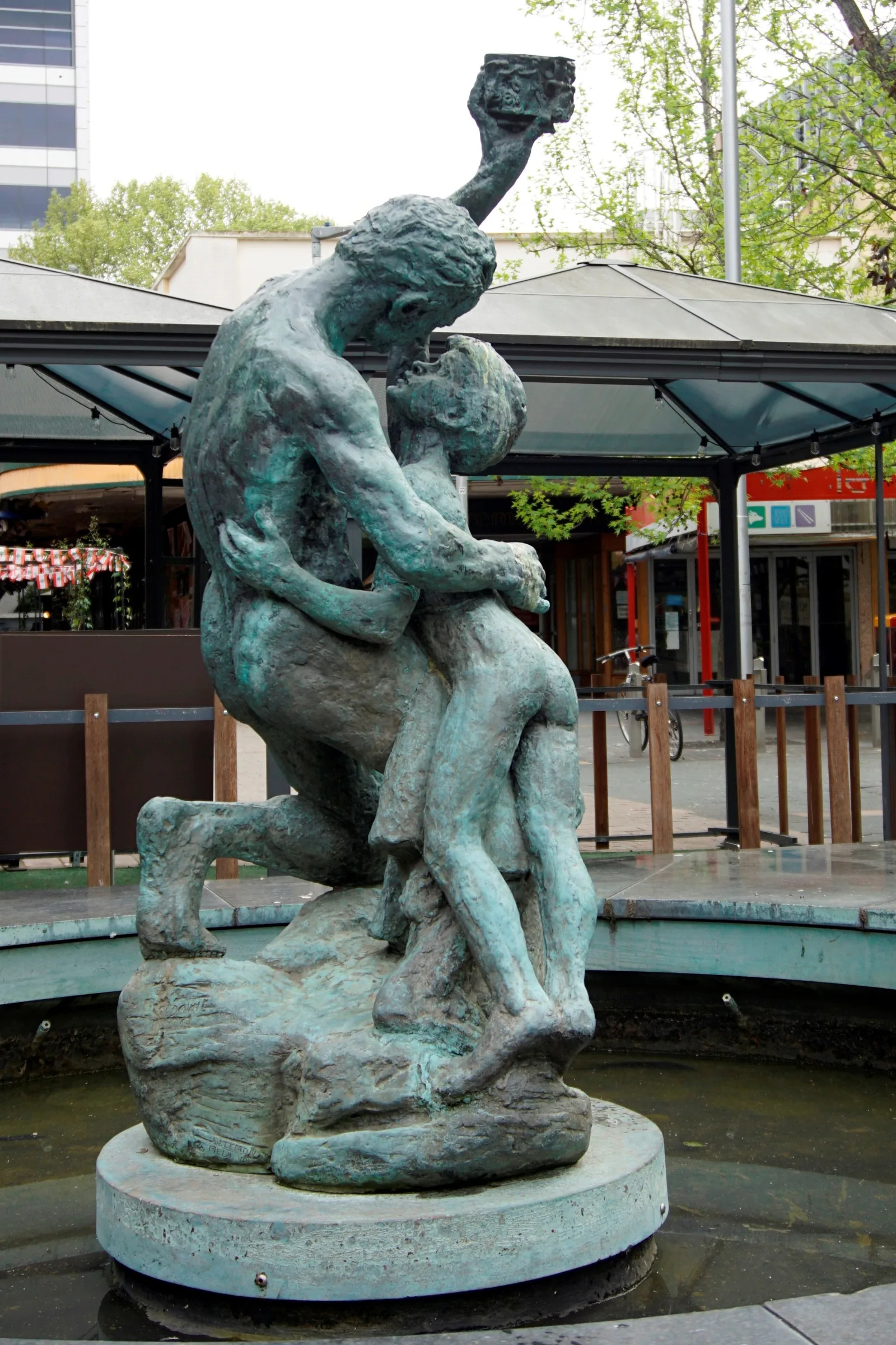 Statue by John Dowie, cast in aluminium, commissioned by the Hon. Alex Downer in memory of his father Sir John Downer, installed in Canberra 1964. It was restored and relocated in Garema Place in 1986. It depicts a father and son in embrace, the father holding aloft some glittering prize, perhaps a challenge to his son that one day it could be his.