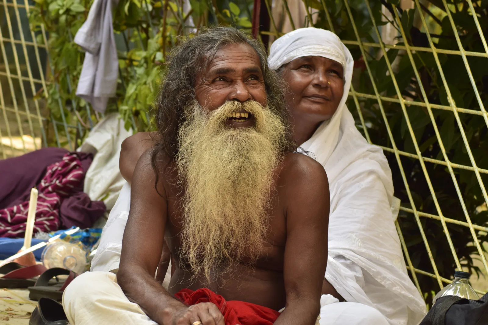 This picture depicts a touching scene of love and compassion between two individuals. The Sufi woman is shown fixing the hair of a man with big hair, a symbol of his devotion to Lalon and his spiritual path. This simple act of kindness reflects the deep sense of love and empathy that is at the heart of Lalon's philosophy. Lalon's teachings emphasized the importance of love and compassion for all beings, regardless of their religion, caste, or social status. By fixing the man's hair, the Sufi woman is demonstrating her commitment to Lalon's teachings and her belief in the power of love to transform the world. The scene is set at Lalon's majar, or shrine, which is a place of pilgrimage for those who follow Lalon's philosophy. This picture captures the essence of Lalon's message and the spirit of devotion that animates the Baul community.