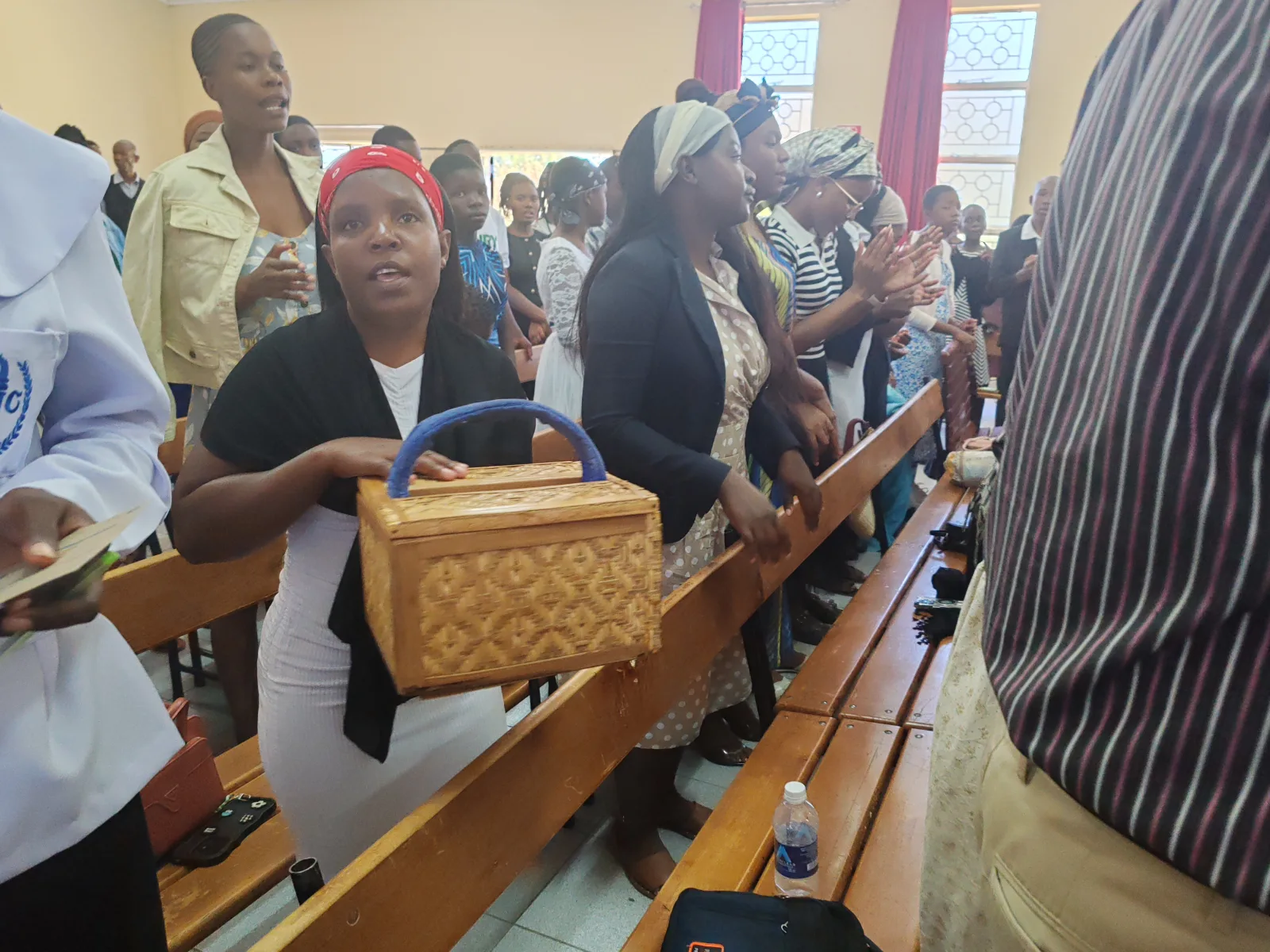 A person passing a basket for Giving tithe and offering