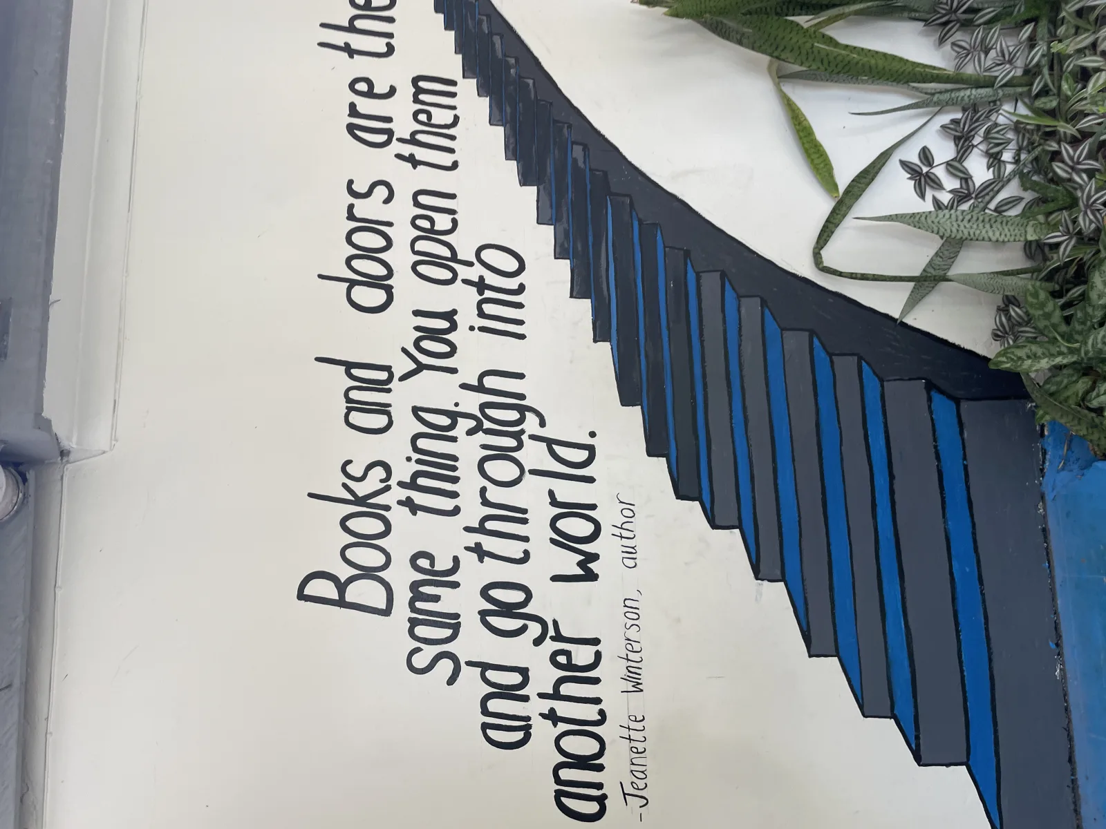 Wall mural on the library at International School of Tanganyika. The quote says "Books and doors are the samet hing. You open them and go through into another world" by Jeanette Winterson.