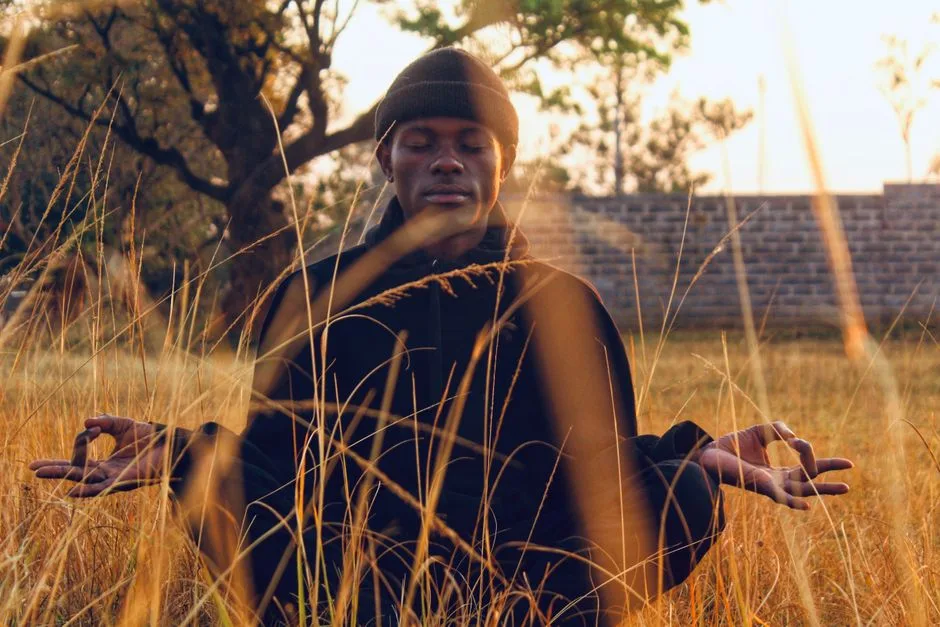 Serene meditation in a grassy field during sunset, capturing peace and mindfulness.