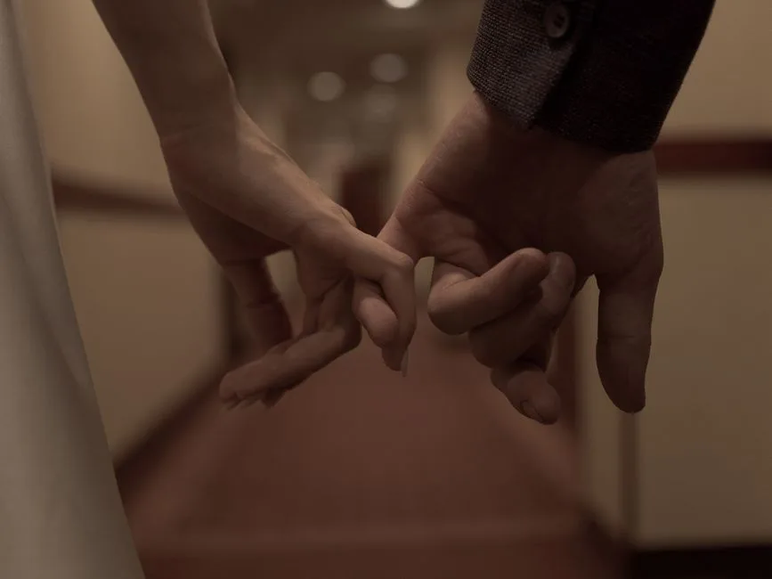Tender close-up of two hands holding each other, symbolizing love and connection.