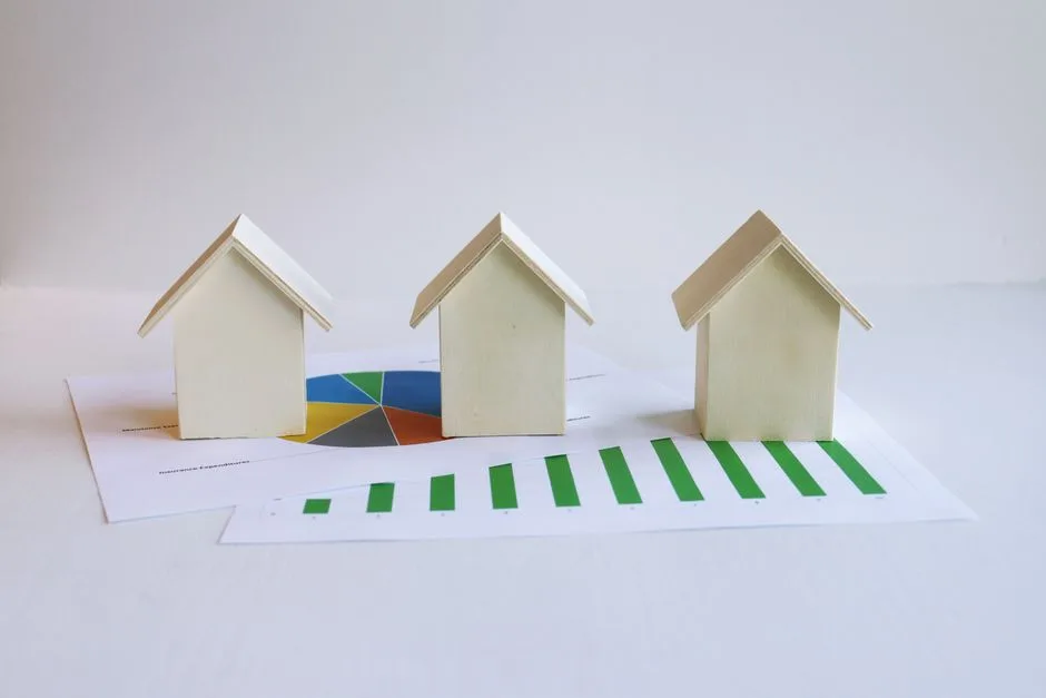 Wooden model houses on graphs depict real estate market analysis and trends.