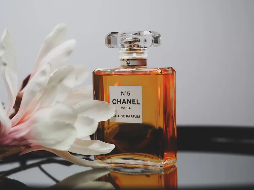 Chanel No. 5 perfume bottle with a delicate flower, reflecting elegance and luxury.