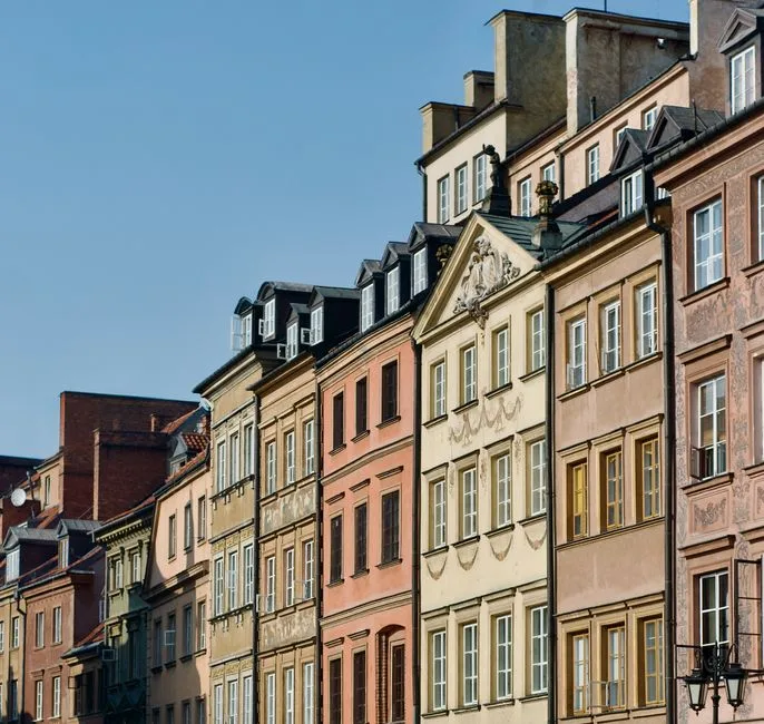 Charming row of colorful historic houses in Warsaw's Old Town on a sunny day.