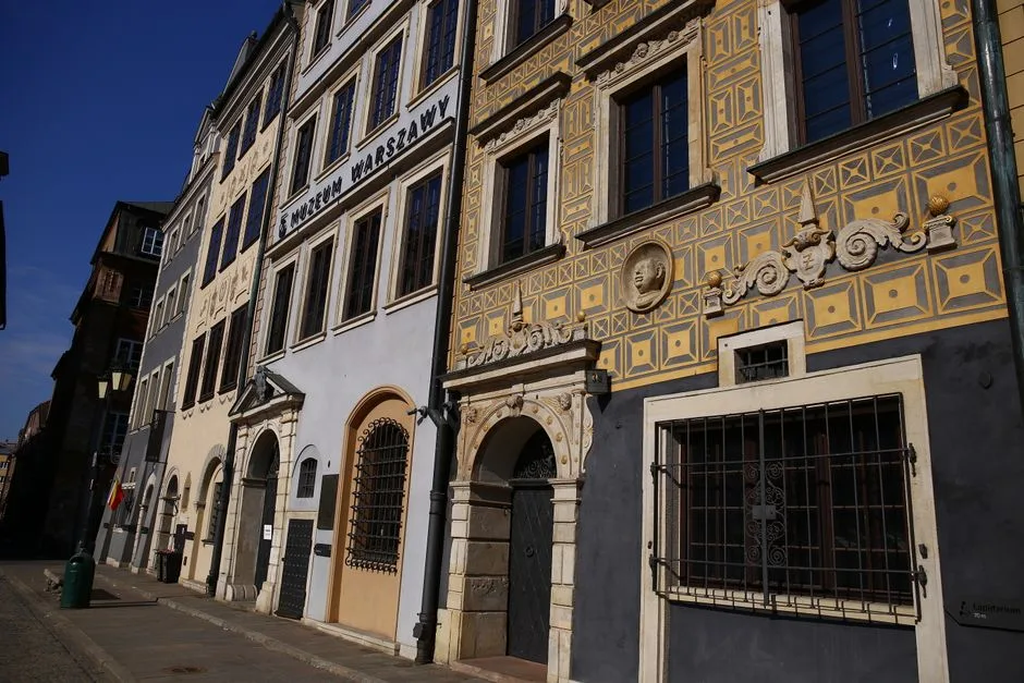 Photo of decorative historic buildings on a sunny street in Warsaw.