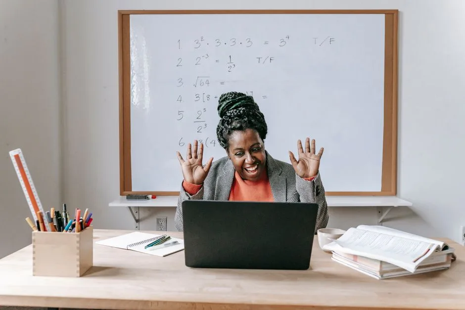 Cheerful African American female teaching online lesson with netbook in modern classroom