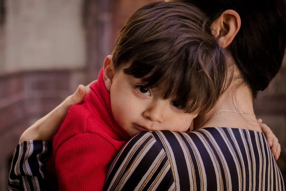 A touching scene of a mother tenderly holding her young son, showcasing love and closeness.