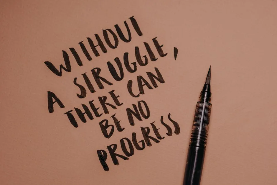 Handwritten motivational quote using a brush pen on a textured background for inspiration.