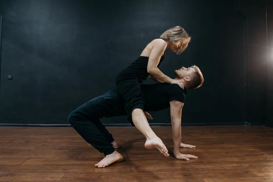 A couple performing expressive dance moves in a contemporary studio.