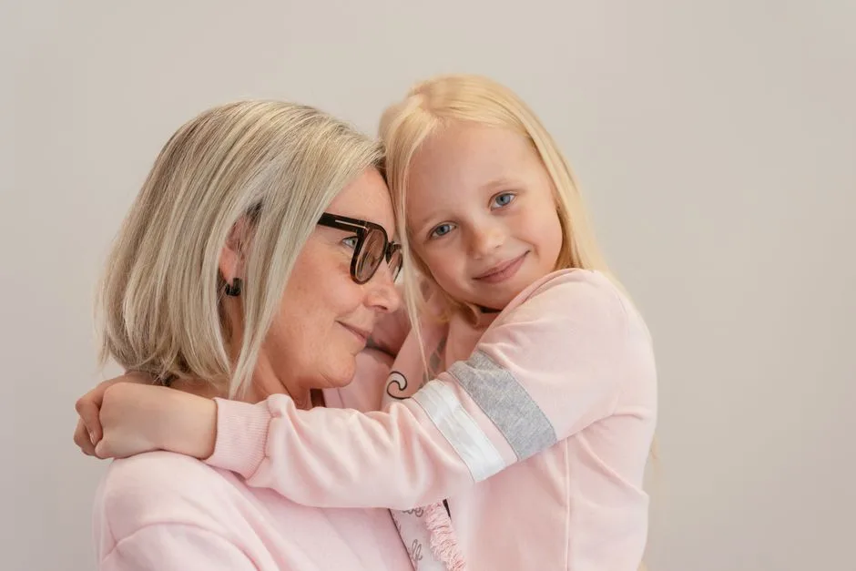 Senior woman and young girl sharing a warm embrace, expressing love and companionship.