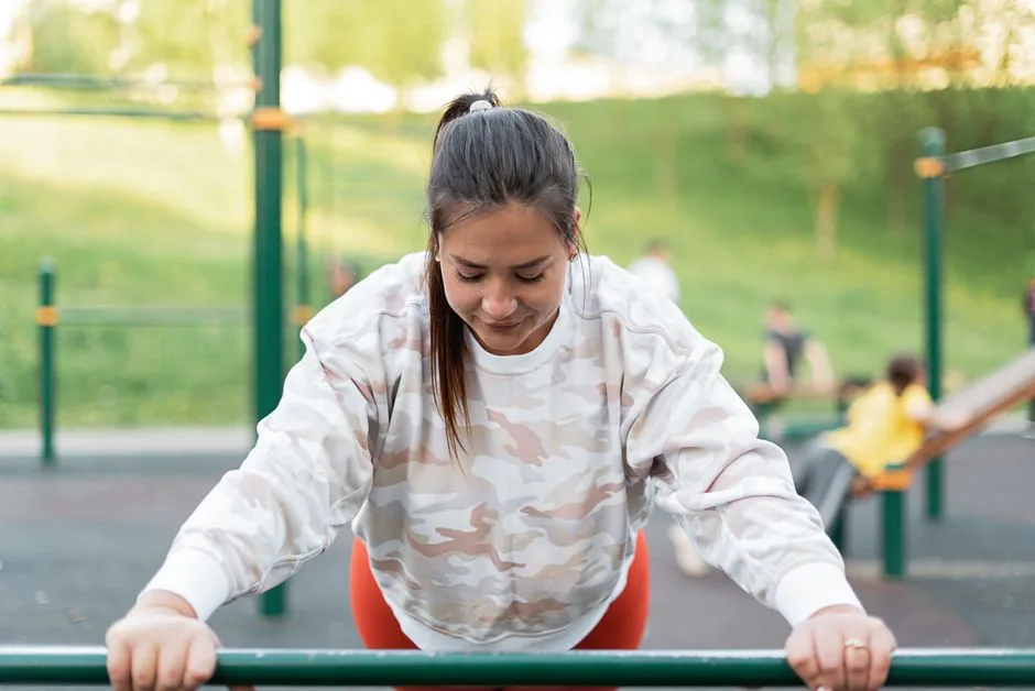 A woman performs exercises at an outdoor park, embracing a healthy lifestyle.