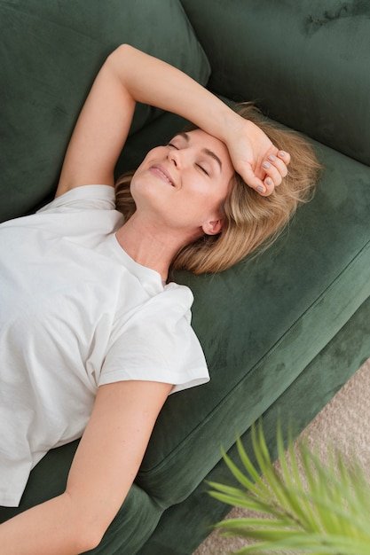 Woman with closed eyes relaxing on the couch