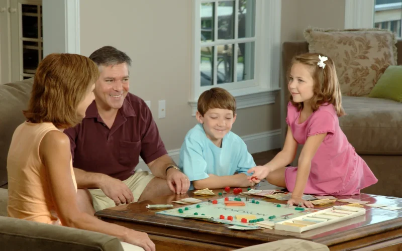 Title Family Playing a Board Description A Caucasian family (adult male and female and two children, male and female) are sitting around a coffee table playing a board game. Topics/Categories People -- Adult People -- Child People -- Family/Friends People -- Recreation Type Color, Photo Source National Cancer Institute (NCI)
