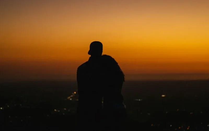 Embracing couple silhouetted against a vibrant sunset in Panama City, Panama.