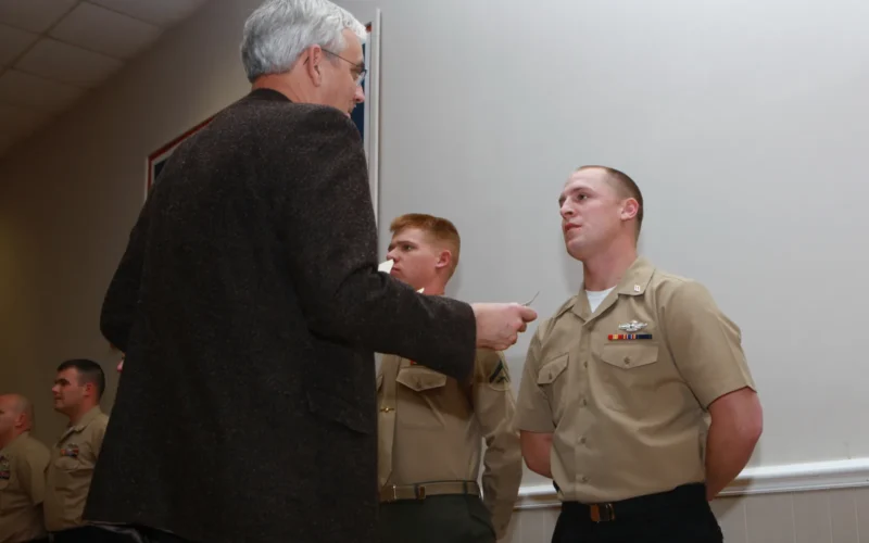 John Falkenbury, the USO of North Carolina president, presents an award to a sailor with Medical Logistics Company, 2nd Supply Battalion, 2nd Marine Logistics Group at the USO in Jacksonville, N.C., March 7, 2013. A group of Marines and sailors received awards for volunteering to help remodel the buildings storage facilities for nonperishable food items.