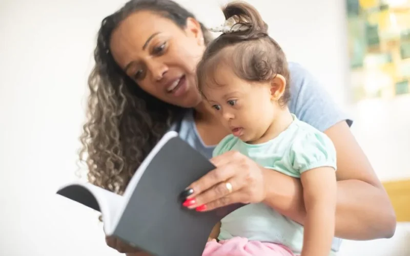 A mother and her young daughter enjoy reading a book together, fostering early learning.