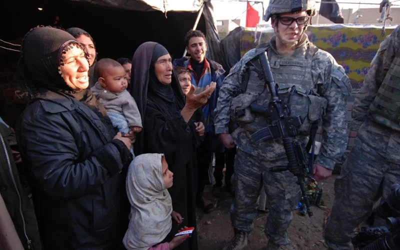 Springfield, Mass. native 1st Lt. Austin Dziengelewski, a platoon leader with Company B, 2nd Battalion, 325th Airborne Infantry Regiment, 2nd Brigade Combat Team, 82nd Airborne Division, gets information from a family of displaced squatters after discovering their refugee camp, Jan. 14. After sectarian violence forced the family to flee their home in another part of Baghdad, they now live in a squalid, makeshift shelter with other refugees in the Sha'ab neighborhood, where 2-325 operates. Later that night, the paratroopers dropped off some supplies to help the family get through the winter.