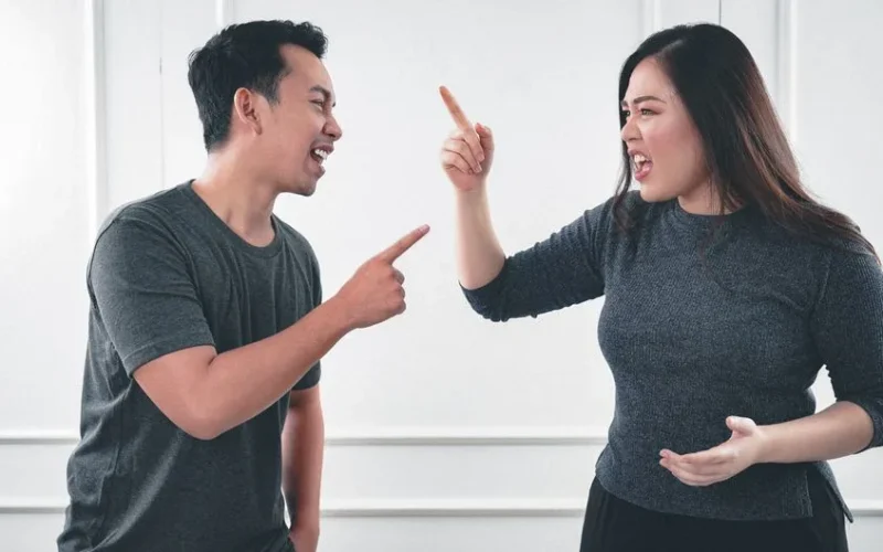A couple engaged in a heated argument at home, expressing strong emotions.