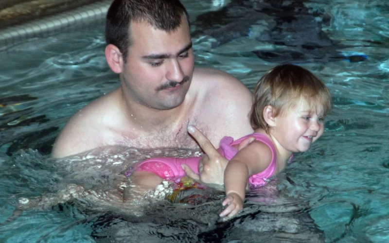 071119-N-2789G-001 SILVERDALE, Wash. (Nov. 19, 2007) Boatswain's Mate 3rd Class Joshua Hammons, stationed aboard the submarine tender USS Emory S. Land (AS 39), works with his daughter on her swimming during a parent and child swim class at the Bangor Fitness Center Pool. U.S. Navy photo by Mass Communication Specialist 3rd Class Angela Grube (Released)
