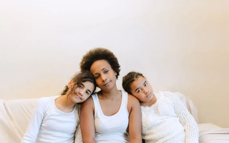 A warm family moment showing a mother with her daughters enjoying quality time indoors.