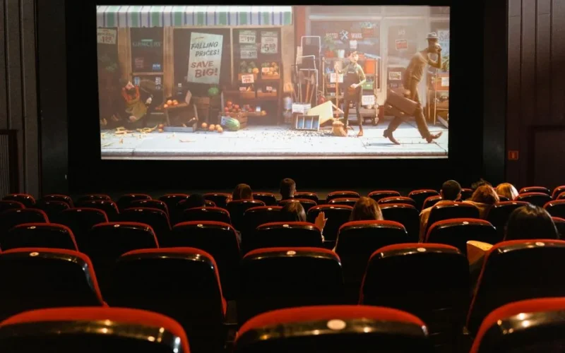 A cozy indoor movie theater showing an animated film to a small audience.