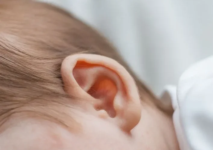 Detailed close-up of a newborn baby's ear, capturing softness and innocence.