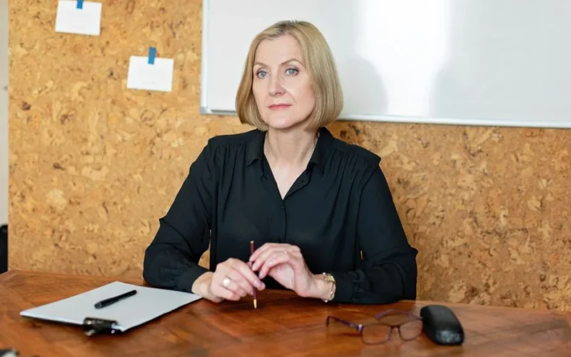 Confident mature businesswoman seated at desk in office environment.