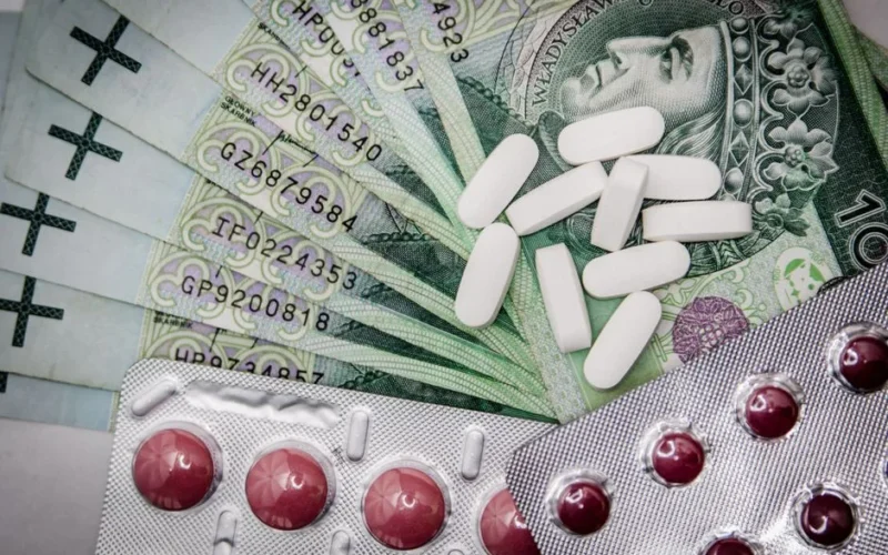 Polish 100 złoty notes with pills and blister packs, illustrating medical costs.