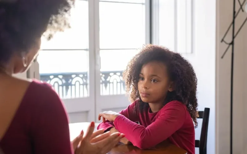 A mother talks to her daughter in a warm family setting, highlighting parenting dynamics.