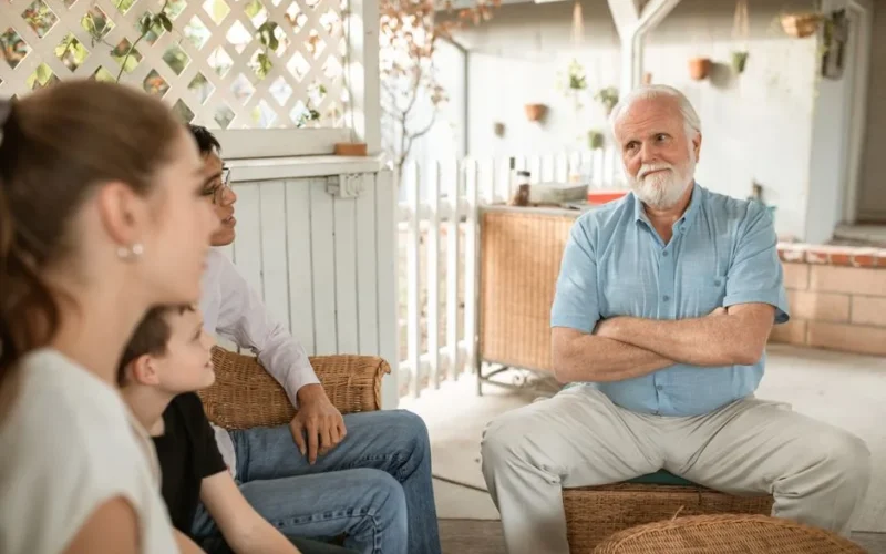 Family gathered indoors, engaged in conversation with a focus on bonds and togetherness.