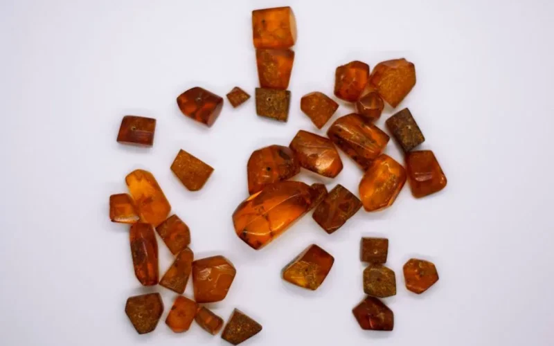 A collection of natural amber gemstones displayed on a white surface.