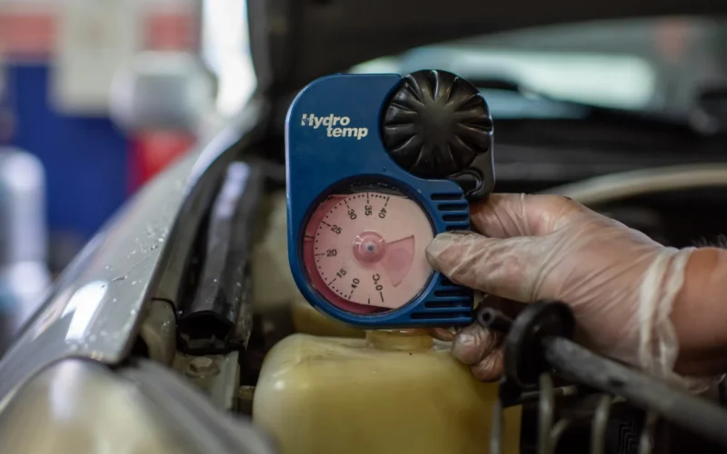 An automotive technician takes the temperature of a vehicle’s radiator fluid during a winter vehicle inspection Oct. 21, 2022, at Spangdahlem Air Base, Germany. Spangdahlem AB hosts annual winter inspections like these to give car owners recommendations to improve their safety and reliability during colder months in the area (U.S. Air Force photo by Airman 1st Class Imani West)
