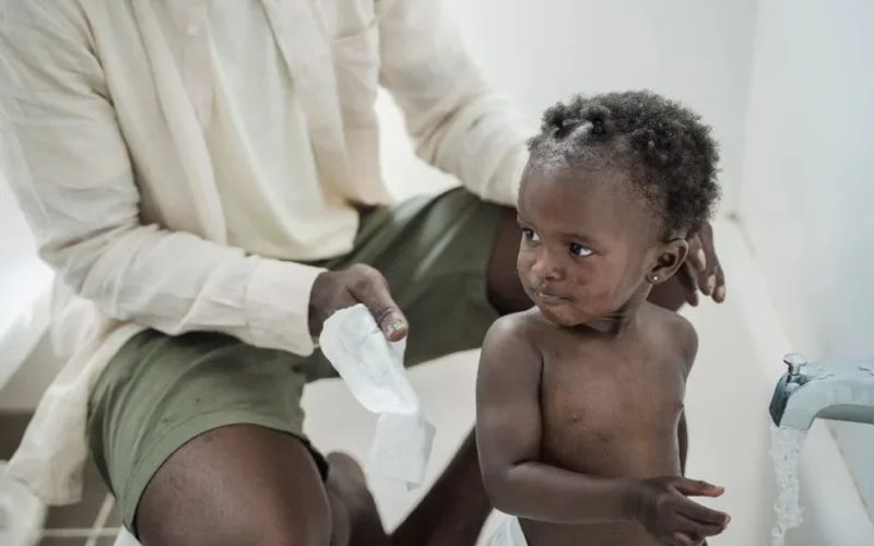 A father lovingly bathes his baby, creating a heartwarming family moment.