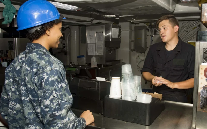 170823-N-FG807-017 PORTSMOUTH, Va. (Aug. 23, 2017) Aviation Boatswain’s Mate (Handling) Airman Jasmine Miller, from Irmo, S.C., left, orders coffee from Airman Steven Swain, from Warner Robins, Ga., right, at the ship's coffee shop aboard the aircraft carrier USS Dwight D. Eisenhower (CVN 69)(Ike). Ike is preparing for a Planned Incremental Availability (PIA) at Norfolk Naval Shipyard during the maintenance phase of the Optimized Fleet Response Plan (OFRP) (U.S. Navy photo by Mass Communication Specialist Seaman Devin Alexondra Lowe) Unit: Navy Media Content Services DVIDS Tags: CVN 69; "USS Dwight D. Eisenhower; NMCS; DVIDS Bulk Import; OFRP