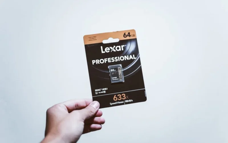 A hand holding a packaged 64GB Lexar Professional SD card, ideal for digital storage.