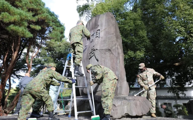 Soldiers assigned to the 765th Transportation (Terminal) Battalion and members of the Japan Ground Self-Defense Force work together to beautify the large “Sobudai” stone monument Nov. 19 on Camp Zama. The effort marked the first time both groups partnered to clean the monument, which sits near the Camp Zama Chapel.