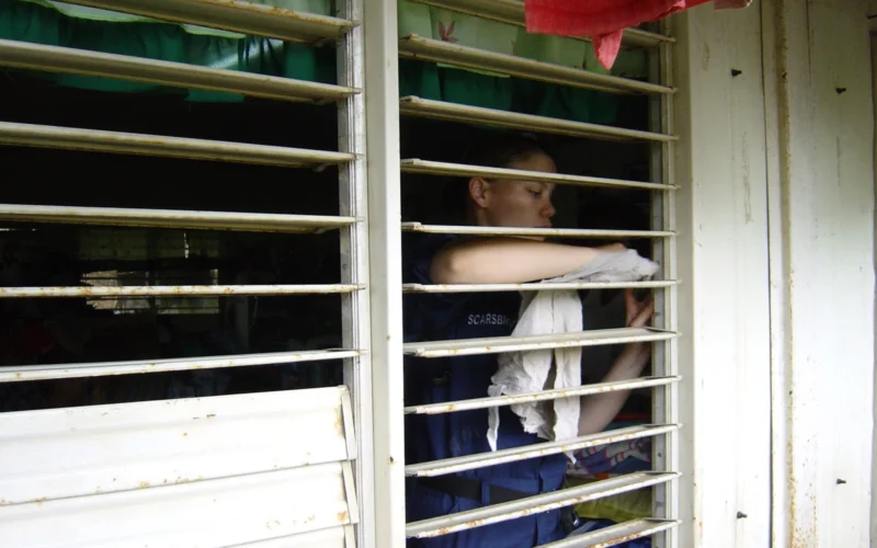 Saint Bernard, Philippines (Feb. 25, 2006) - Quarter Master 3rd Class Carrie Scarsbrook, assigned to the amphibious dock landing ship USS Harpers Ferry (LSD 49), cleans window blinds of a classroom during a community service project at St. Bernard Elementary School in southern Leyte. Sailors and Marines from USS Curtis Wilbur (DDG 54), USS Harpers Ferry (LSD 49) and USS Essex (LHD 2) arrived off the coast of Leyte Feb. 19 to provide humanitarian assistance and disaster relief to victims of the Feb. 17 landslide on the island of Leyte, Republic of the Philippines. U.S. Navy Photo by Lt. Ed Sisk (RELEASED)