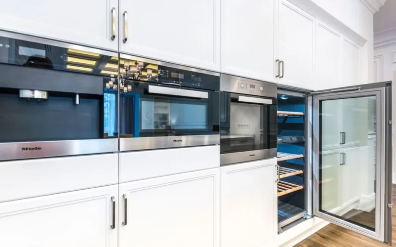 A sleek contemporary kitchen featuring built-in appliances and minimalist white cabinets for a spacious look.