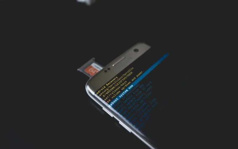 Close-up of a smartphone displaying Android recovery mode with an SD card inserted.