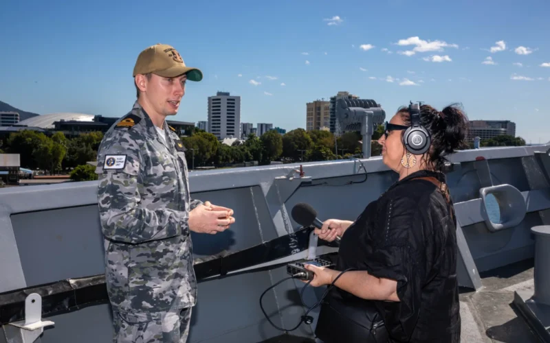 CAIRNS HARBOUR (June 10, 2024) – Royal Australian Navy LEUT Joseph Melbin, officer in charge of Fleet Support Unit Guam Deployed Maintenance Team assigned to the submarine tender USS Emory S. Land (AS 39), a native of Queensland, Australia, left, speaks with local media outlets during a tour of the ship while moored at HMAS Cairns for a regularly scheduled port visit, June 10. Cairns is Emory S. Land’s second port since it departed on deployment May 17. Emory S. Land is on deployment supporting the U.S. 7th Fleet, the U.S. Navy’s largest forward deployed numbered fleet, operating with allies and partners in preserving a free and open Indo-Pacific region. Emory S. Land provides expeditionary intermediate-level maintenance, services, and logistics support to deployed submarines. (U.S. Navy photo by Mass Communication Specialist 2nd Class Darek Leary)