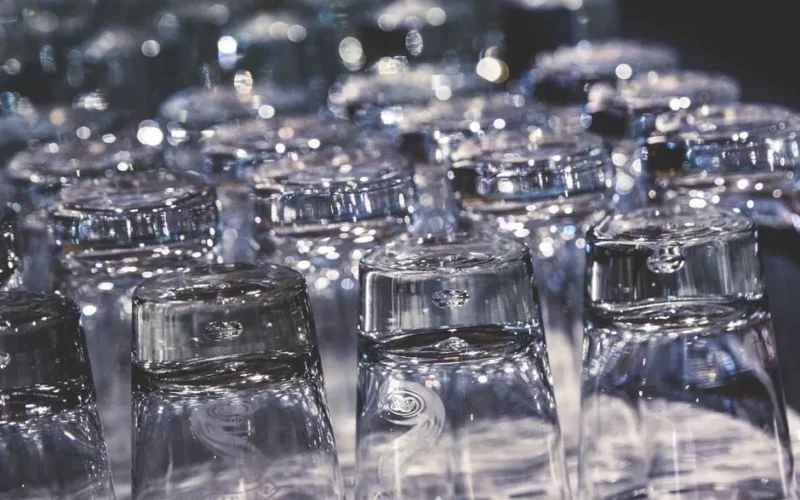 Close-up of crystal clear upside-down drinking glasses with an elegant reflection.