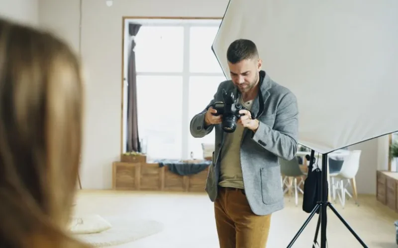 Photographer reviewing camera while setting up a shot in a studio.