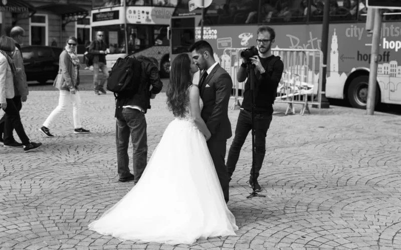 Black and white photo of a bride and groom embracing on a busy city street.