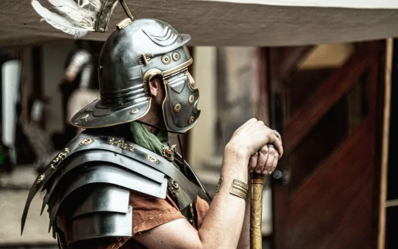 A Roman legionary in full armor, showcasing historical attire with a feathered helmet.