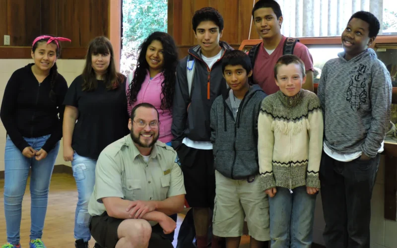 Recently, the BLM went back to school and made nature come to life for a gaggle of middle-schoolers! The BLM’s Salem District Law Enforcement Officer, George Dawn, Fred Greatorex (a.k.a the “New Johnny Horizon”), and Yaquina Head Outstanding Natural Area bilingual intern, Lucila Fernandez, helped out with the Oregon State University’s International 4-H Camps in Salem, Oregon. Salem District Law Enforcement Officer George Dawn kicked off his presentation by contrasting a day in the life of a city police officer, a state trooper, and specifically a BLM ranger protecting natural resource lands. He then demonstrated the police tools, (taser and cartridge, expendable baton, pepper spray, handcuffs, officer worn camera and personnel tourniquet), that he carries on the job. He gave a handcuff demonstration and the students, in turn, got a chance to show George what they learned. George’s impact was very evident when a Bill and Melinda Gates scholarship recipient said he would “…like to pursue a career as a ranger!” Assistant archaeologist Fred Greatorex, dressed as Johnny Horizon, shared his stone and field kits containing volcanic rocks, bones, antlers and artifacts with 4-H middle-schoolers. Fred’s presentation sparked curiosity from the students when they started asking questions about the rock’s origin and its purpose. “I love seeing kids’ eyes light up when they make the connection with archaeology, in that at one time, woolly mammoths and ancient bison roamed the Willamette Valley,” said Greatorex. Lucila Fernandez, bilingual intern at Yaquina Head through a Partnership with Environment of the Americas, taught the students about migratory birds. Lucila showed them how to use a bird book and binoculars to identify birds found along the Oregon Coast and then helped them observe and identify local birds. The “4-H International Summer Camps” focuses its efforts to increase the numbers of children and youth from different cultural backgrounds (Native Americans, African American, Latinos, Asian Americans, Middle Eastern, and Caucasians who are first generation going to college), involvement in 4-H to help them to advance to a professional career with the support of community-based organizations, private businesses, Oregon 4-H, and Oregon State University professionals from different colleges and departments. In Oregon, children and youth from underserved populations, generally do not participate in community-based educational opportunities like after school programs and summer camps. Further, they lack information about careers and how to prepare for college. The summer camps are six-day overnight programs that provide an intensive educational experience for middle school youth. These camps are part of a larger effort to engage underserved children and youth in activities that will help them improve their academic skills, develop leadership skills, learn about career opportunities, how to prepare for college, meet professionals from their own cultural background, meet recruiters from different colleges and universities, and engage them in healthy physical activities. 4-H uses the “Role Model Philosophy” as follows: middle school students participate as campers, high school students as camp counselors, college students as advisors, supervisors, and instructors, and adult professionals as role models, instructors, and speakers. Participants come from all over Oregon. This year, about 90 campers per camp participated. An average of 34 high school students served as counselors. The adult volunteers averaged about 20 per day. These included college students, professionals, community and organization volunteers and the 4-H staff. More information on BLM's environmental education programs is available online at: <a href="http://www.blm.gov/or/education/index.php" rel="nofollow">www.blm.gov/or/education/index.php</a>