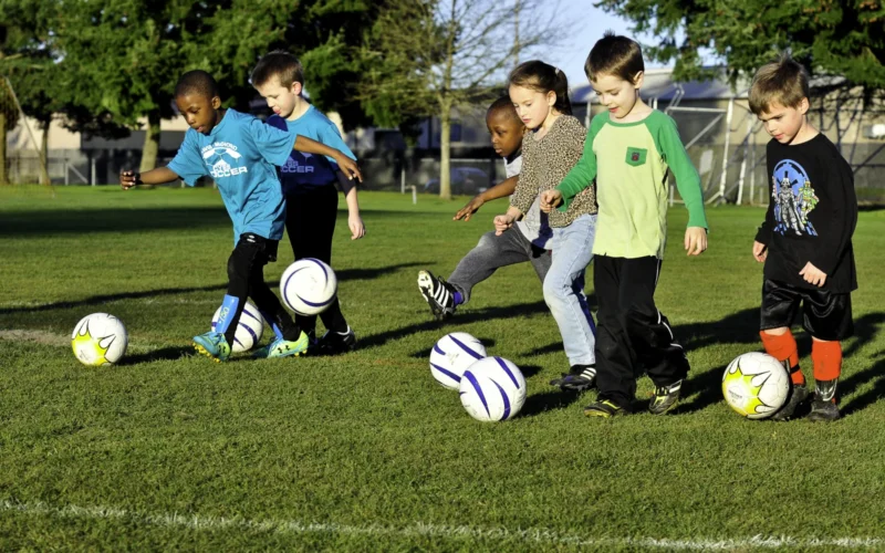 Children work on short kicks as they move towards the goal as part of a dribbling exercise as directed by their volunteer coach to build their confidence and skill during a practice at Joint Base Lewis-McChord, Wash. March 9. The volunteer coaches provide direction, instruction and motivation while building each child's confidence and self-esteem.