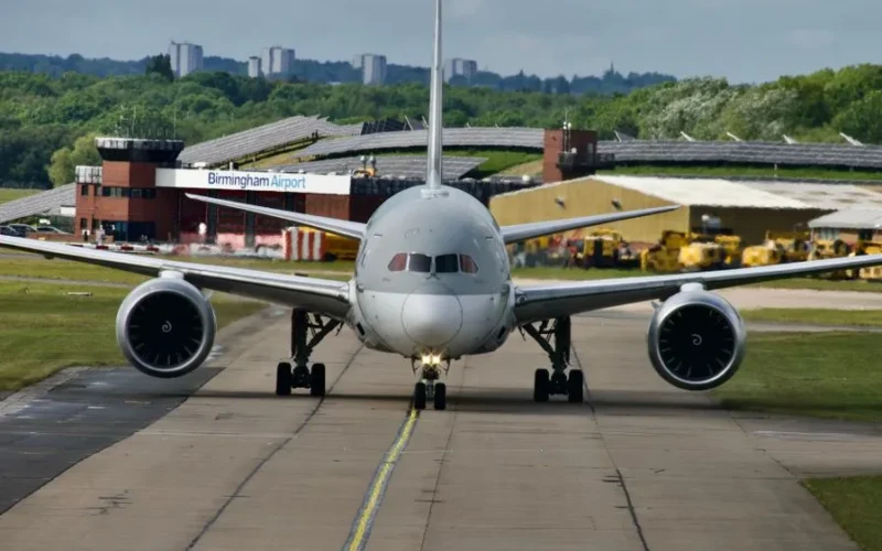 A commercial jet prepares for takeoff at Birmingham Airport on a clear day.