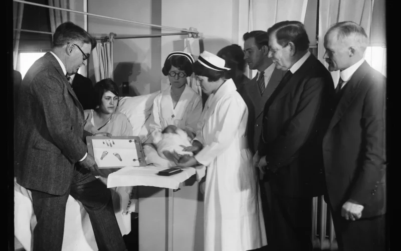 Title: Newborn infant with footprints and group at hospital Abstract/medium: 1 negative : glass ; 4 x 5 in. or smaller
